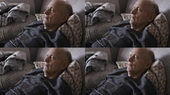 老人，累了，睡在疗养院客厅的沙发上，康复，精力充沛，健康。睡觉，放松和平静的老年男性在沙发上，以获得