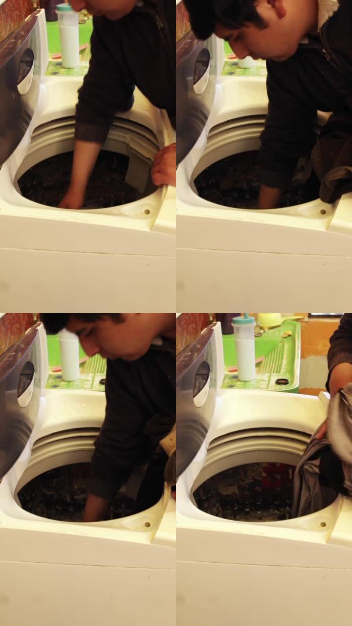 西班牙裔男子把衣服放在洗衣机里
