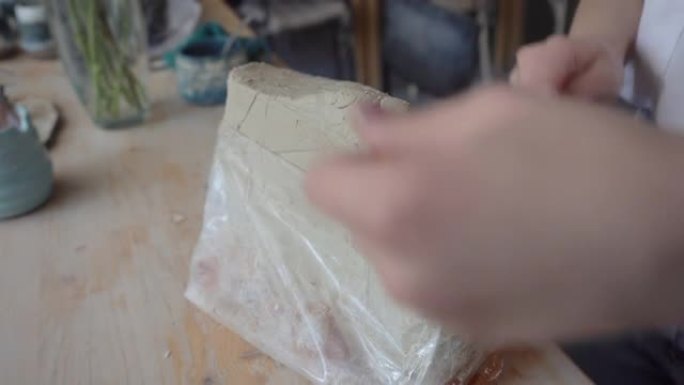 一个女人用钢线切割粘土。