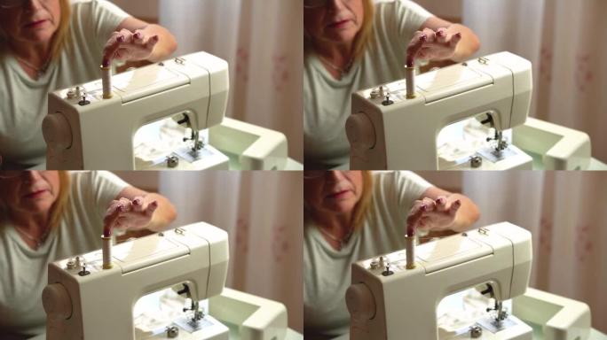戴眼镜的老年妇女在家使用缝纫机-工作和爱好概念