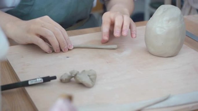 陶工为粘土建模准备粘土。陶艺作坊班。