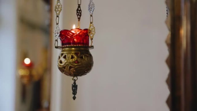 寺庙里的蜡烛挂在碗里，锁链上燃烧。射击运动中的宗教物体