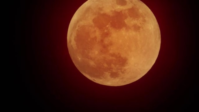 红色的月亮在红色的天空中移动，乌云覆盖着月亮