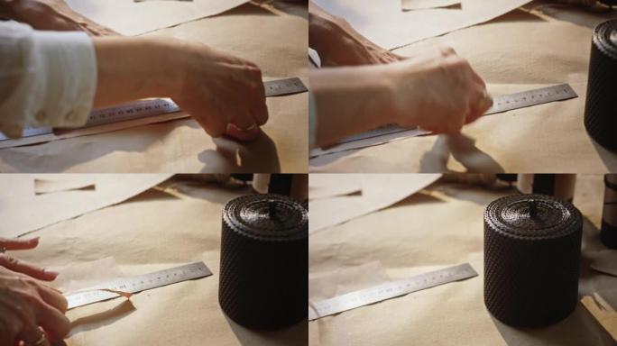 女士用尺子测量双手，撕下棕色纸片。女人的手测量并撕下一张纸。长指甲的女性手用金属尺测量，撕下棕色纸片