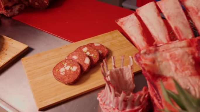将自制香肠切片放在木制切菜板上，以及猪肉和羊肉。