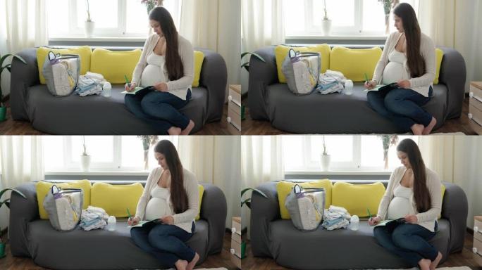 可爱的孕妇为妇产医院写装箱单笔记本准备包。怀孕的年轻莱迪在家里的黄灰色沙发上玩得开心。母亲，医学保健