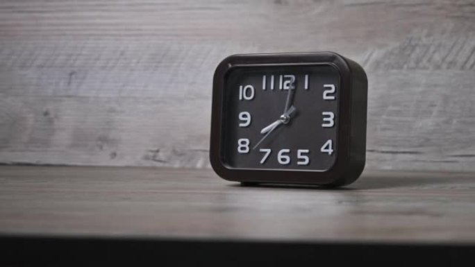 木桌上的指针时钟显示时间