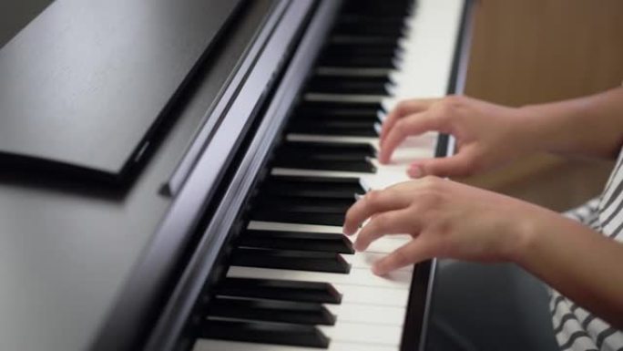 年轻女子在家练习钢琴。成人，音乐家的手喜欢演奏数字钢琴。乐器自学