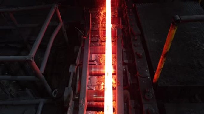 热金属坯在热冶金车间的辊子上移动。轧钢厂、冶金厂、钢厂。钢铁工业