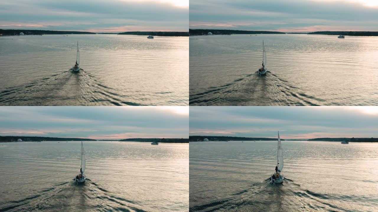 一艘游乐游艇正在湖面上驶向日落。非常凉爽的光线