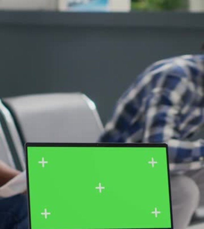 垂直视频: 非洲裔美国护士看着带绿屏的笔记本电脑