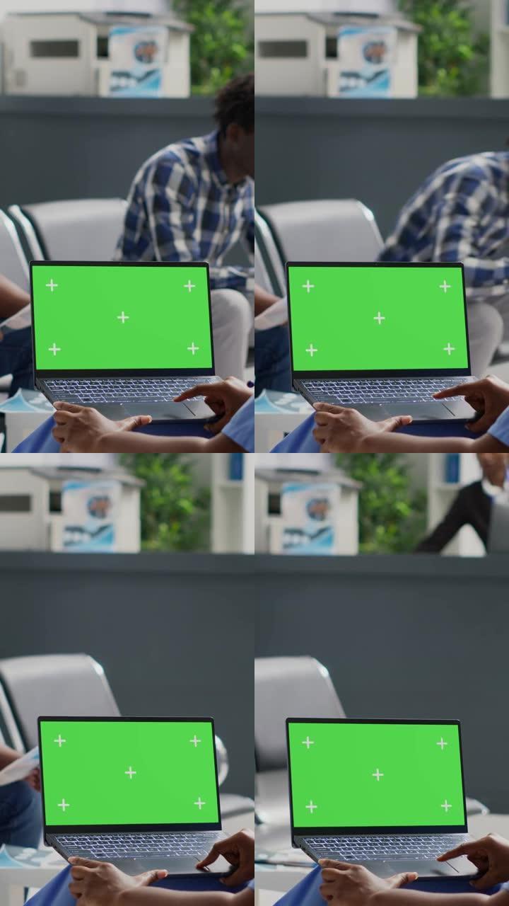 垂直视频: 非洲裔美国护士看着带绿屏的笔记本电脑