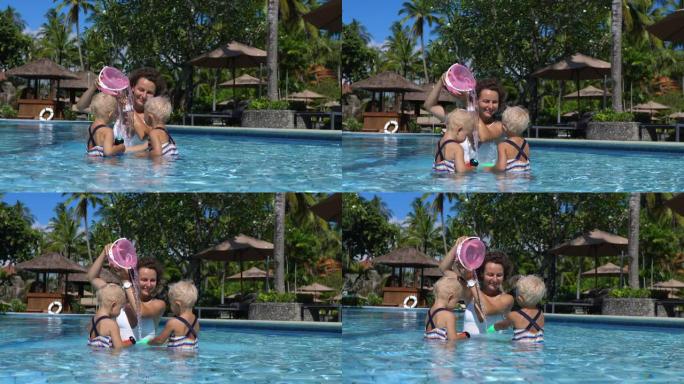 母亲和孩子们一起在游泳池里玩游泳玩具。妈妈把水桶放在头上，从里面倒水，模仿瀑布。假期让孩子们忙碌的小