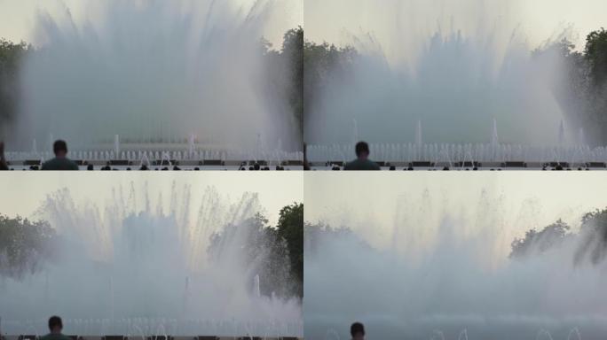 在西班牙加泰罗尼亚巴塞罗那演唱Montjuic魔术喷泉表演的日落前拍摄的一天。在人的前景剪影中。高质