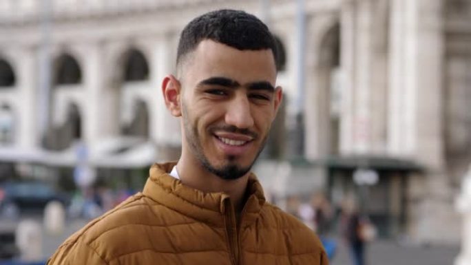 突尼斯迷人的年轻人在城市对着镜头微笑
