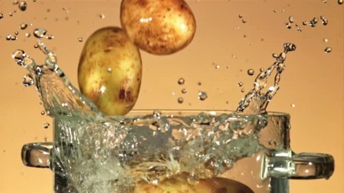 新鲜的土豆溅入一锅水中。以1000 fps的高速相机拍摄。