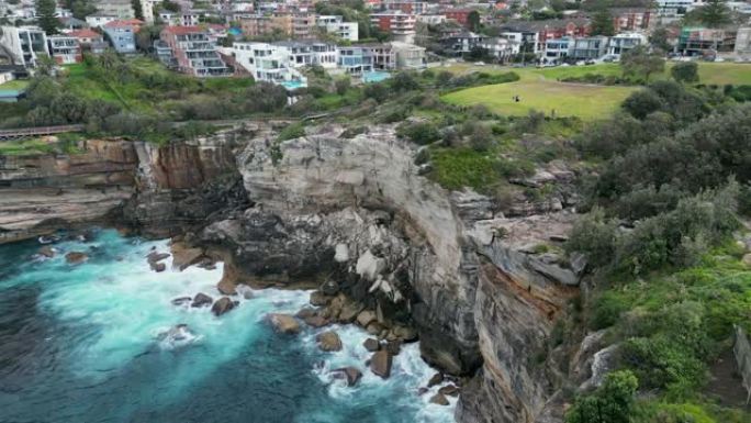无人机拍摄了绿色植被附近的岩石悬崖和水