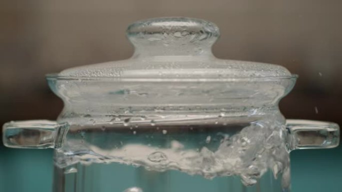慢动作在透明锅中煮水。厨房平底锅里的大水泡。