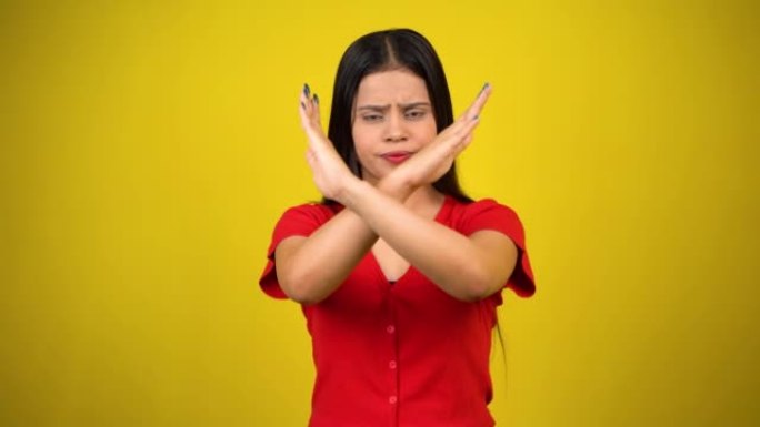 一个亚洲美丽的年轻女子的肖像不快乐或自信的站立说不，工作室拍摄孤立的黄色背景，印度女性姿势说拒绝手势