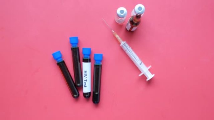 红色背景上的HIV血液试管和注射器