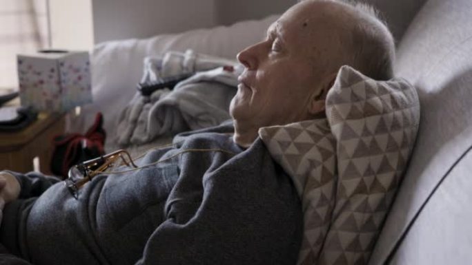 在养老院的沙发上放松，睡觉和退休男子，以实现和平，健康和老年健康。梦想，疲惫和年长的人在舒适的沙发上