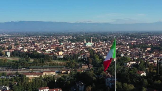 在阳光明媚的秋日里，意大利北部威尼托维琴察市中心的美丽无人机景观，城市天际线和意大利国旗上有主要建筑