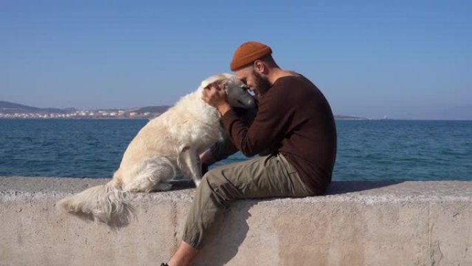 男人拥抱他的宠物狗金毛猎犬。狗主人在长时间分居后想念他的动物朋友。孤独和友谊。健康，生活方式活动。