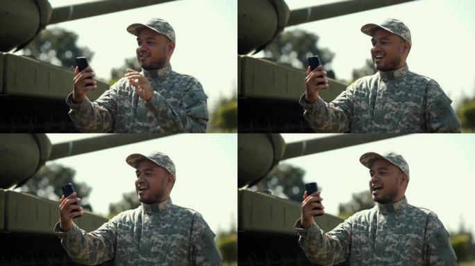 穿着军装特种部队的士兵使用智能手机联系你的家人执行实地任务。战争状态时，身穿制服的国家士兵军事捍卫者