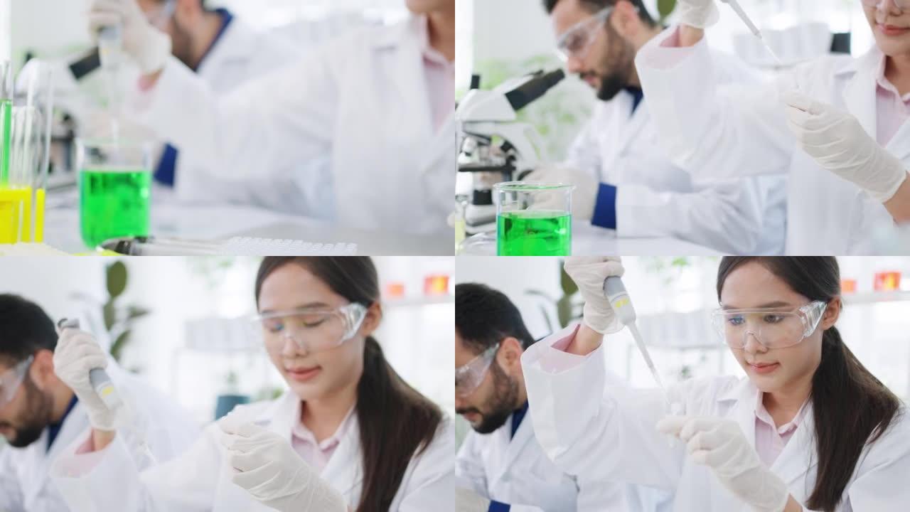 年轻的亚洲研究人员使用微量移液管将绿色溶液转移到eppendorf管中。在现代实验室从事医学、生物技