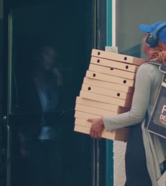 垂直视频: 女送货员提着一堆披萨盒