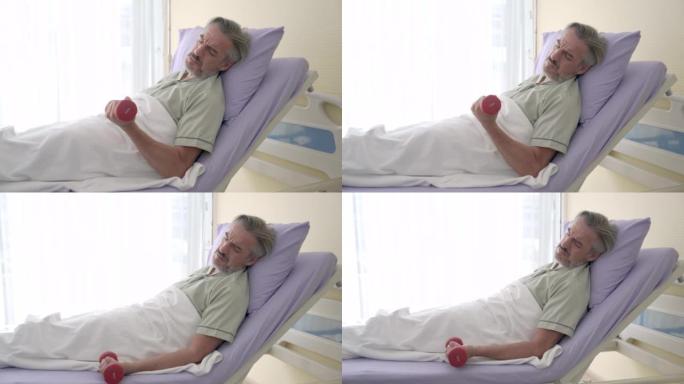 老年高加索患者在医院康复期间举起哑铃，为肌无力患者进行物理治疗。