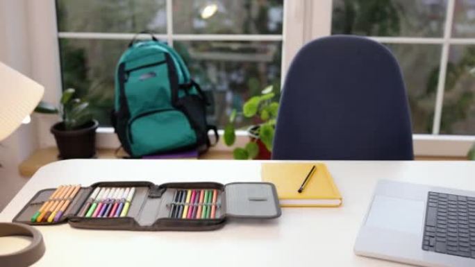 笔记本电脑、铅笔盒和课桌上的学习用品，在房间里