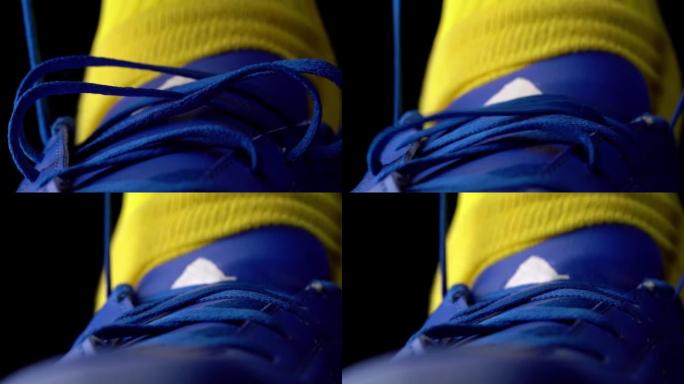 足球运动员在足球防滑钉上系鞋带，特写，慢动作