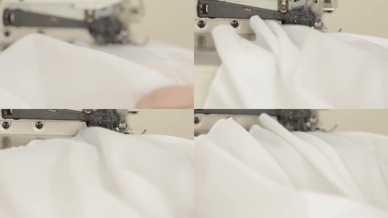 包缝机绣花薄纱面料生产连衣裙。特写