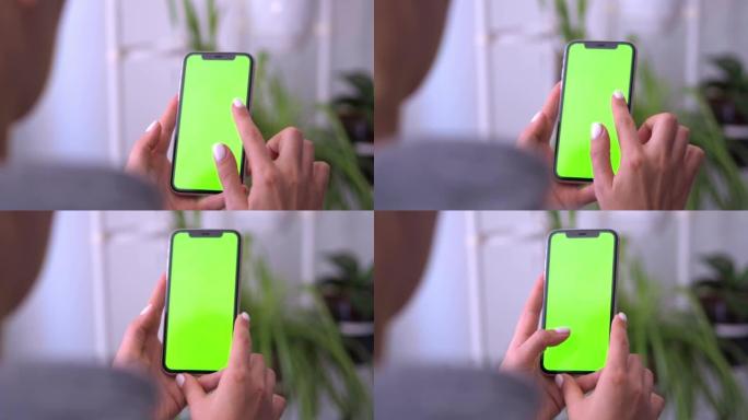 从手机上的女人的背面看，绿屏显示复印空间。