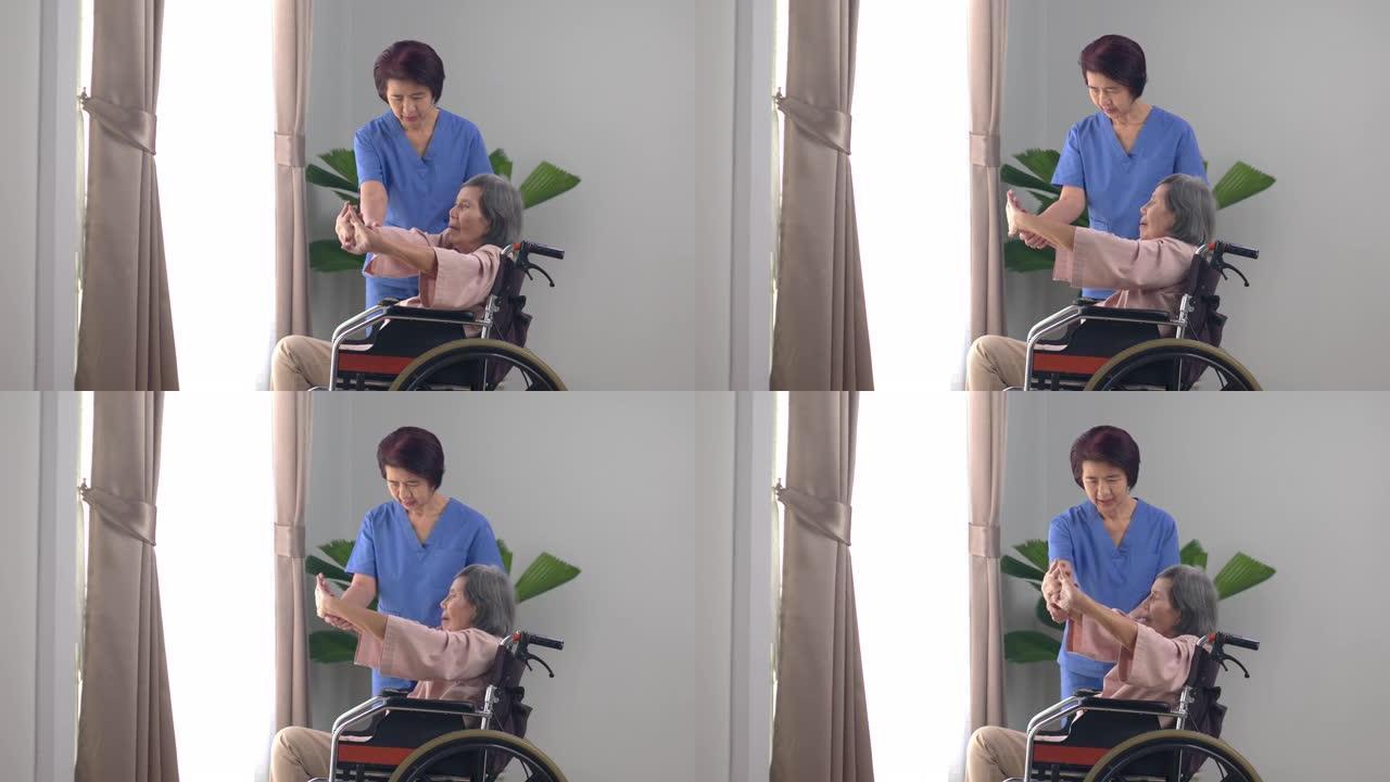 亚洲老年妇女在家与理疗师一起在客厅的轮椅上做伸展运动。。