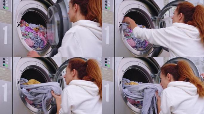 家庭主妇年轻女子做家务，忙于常规的家务工作，把毛巾放进洗衣机，在舒适的洗衣房里打开现代洗衣机烘干机。