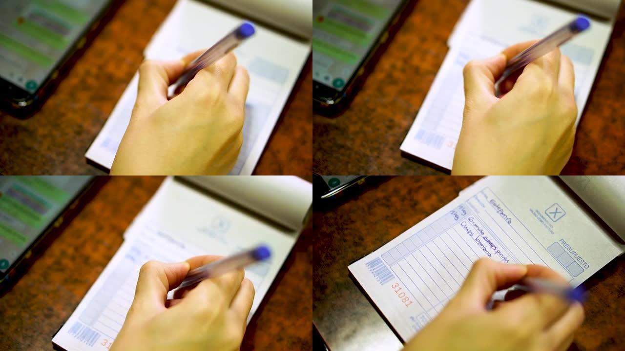 一只女性手握笔并在高清笔记本上书写的俯视图