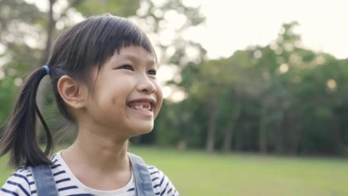 年轻快乐的亚洲小女孩的肖像在公园玩得开心。特写笑脸女孩。7岁漂亮的小女孩掉了乳牙。乳牙脱落，恒牙更换