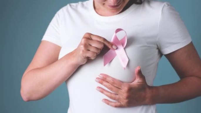 乳腺癌意识丝带。手持粉红丝带的女人