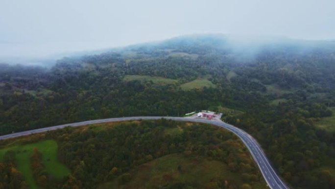 无人机空中加油站与秋晨山路孤车笼罩浓雾
