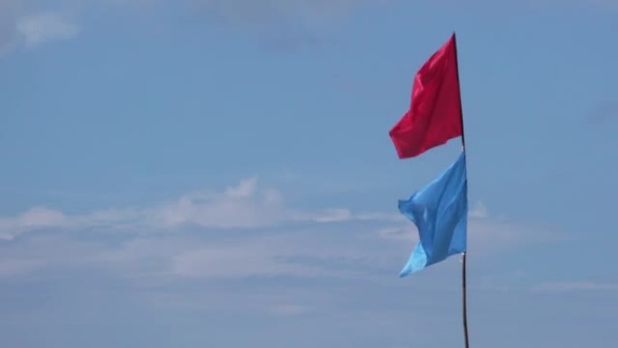 海滩蓝天背景上的彩色旗帜