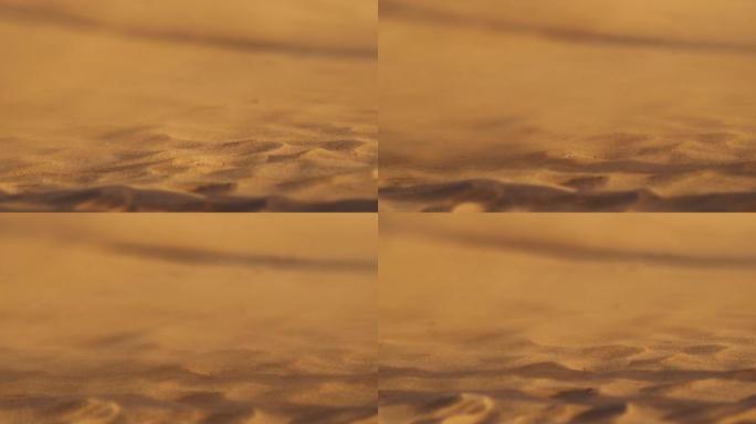 沙漠沙丘中的沙子随风飘动。慢动作镜头，沙子吹过沙丘，戈迪什·沙粒在沙漠中随风飘扬