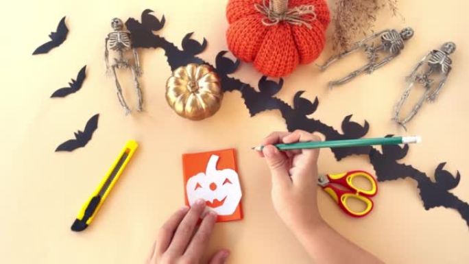 为万圣节假期创建儿童纸装饰花环。