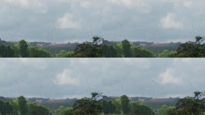 风力涡轮机在山上发电，白天天空，可再生和清洁能源，为未来减少碳排放的概念，从很远的距离拍摄。