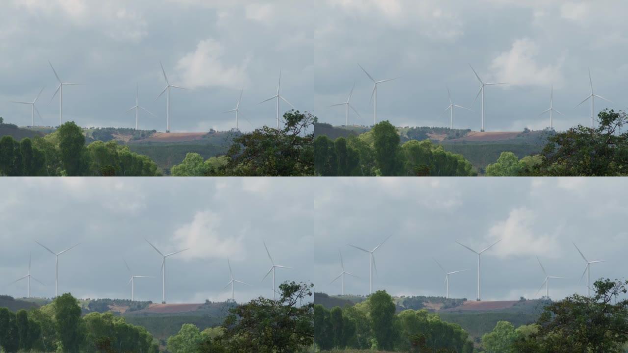 风力涡轮机在山上发电，白天天空，可再生和清洁能源，为未来减少碳排放的概念，从很远的距离拍摄。