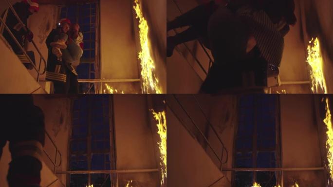 勇敢的消防员走下燃烧的建筑物的楼梯，将被拯救的女孩抱在怀里。开火，一名消防员在后台。