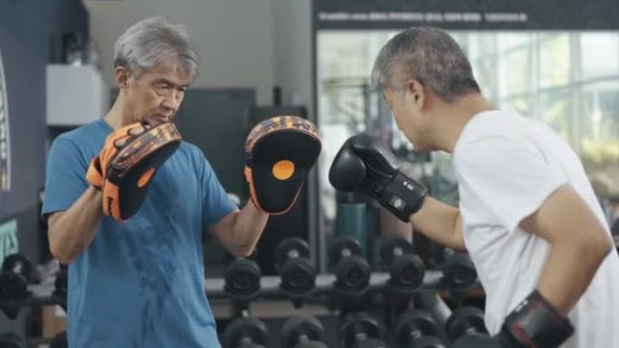亚洲中国高级男子在例行的周末活动中在体育馆练习拳击比赛