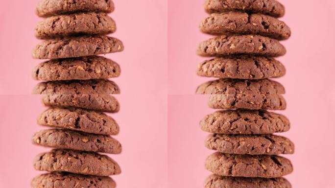 棕色燕麦饼干金字塔在粉红色背景上旋转。自制饼干。