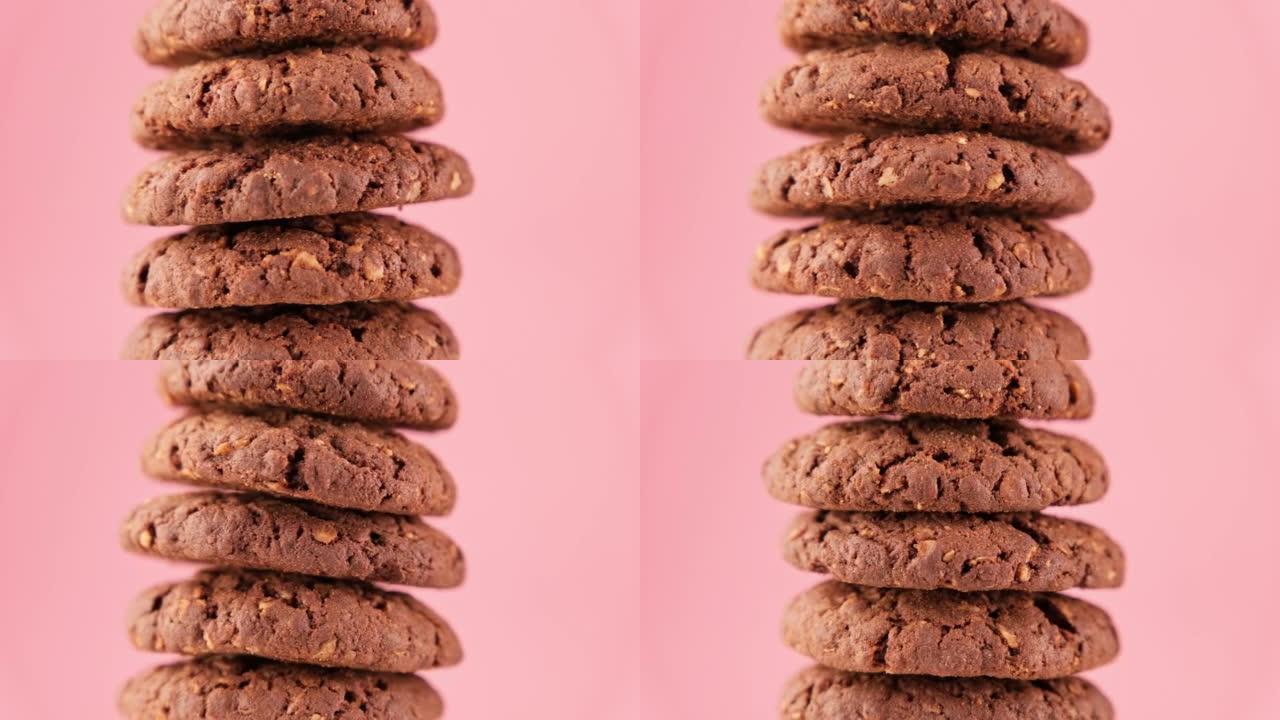棕色燕麦饼干金字塔在粉红色背景上旋转。自制饼干。